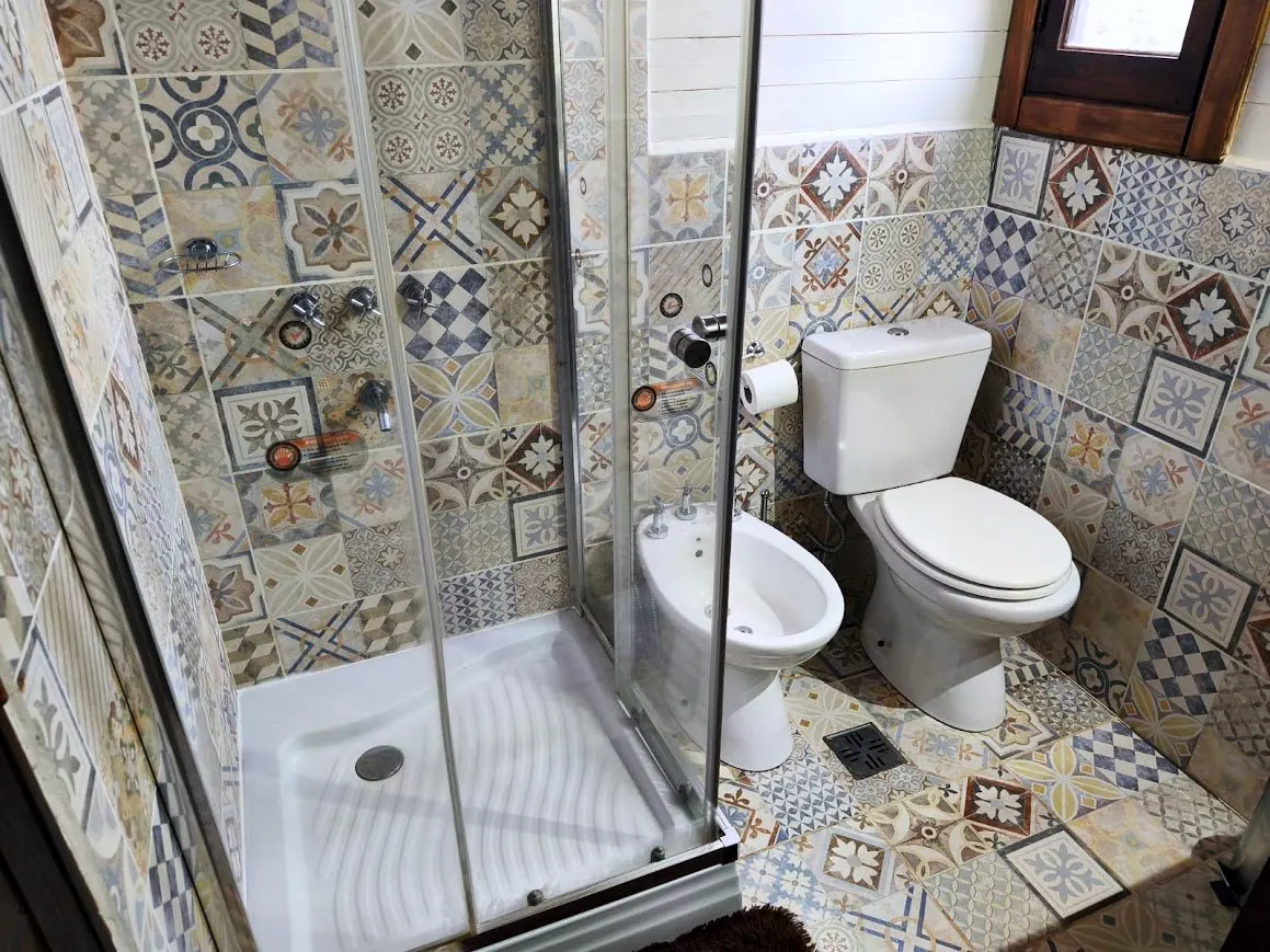 Baño completo de la Cabaña Chuña 1 con ducha y azulejos calcáreos