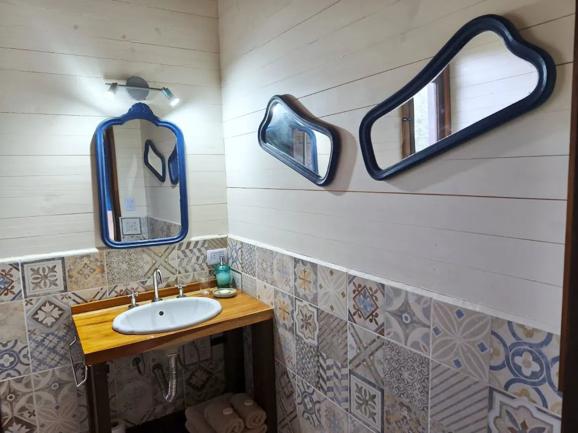 Bacha y espejos antiguos en el baño de la Cabaña Chuña 1