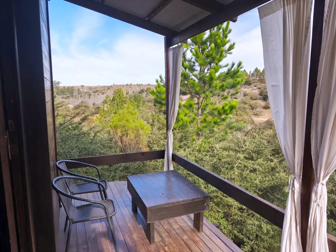 Galería de la Cabaña Chuña 1 con sillones y vista al monte serrano