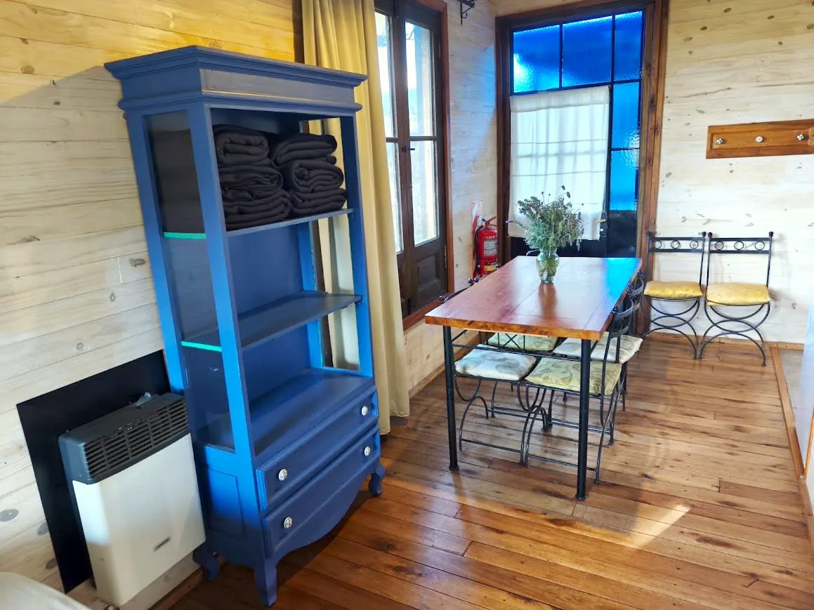 Comedor de la Cabaña Chuña 2 con mesa para cuatro, calefactor a gas y mantas de abrigo
