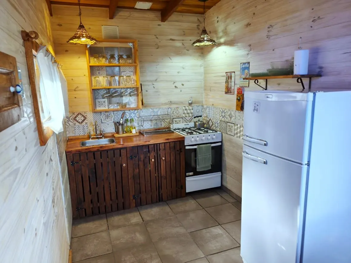 Cocina equipada de la Cabaña Chuña 2 con cocina a gas, heladera y vajilla completa