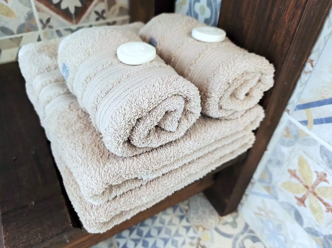 Toallas y toallones con jabones de cortesía en el baño de las cabañas