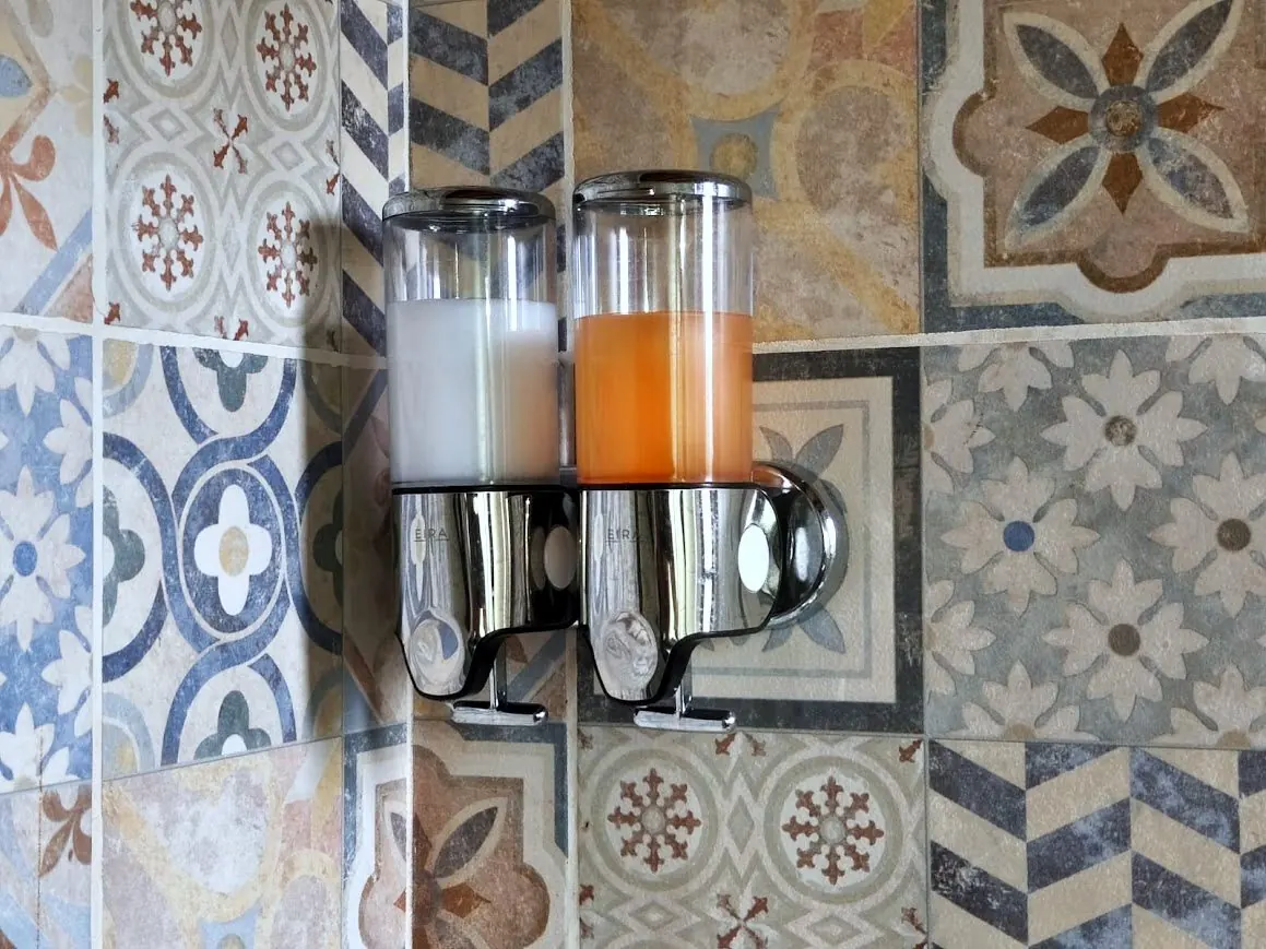 Dispenser de shampoo y acondicionador de cortesía en la ducha de la cabaña