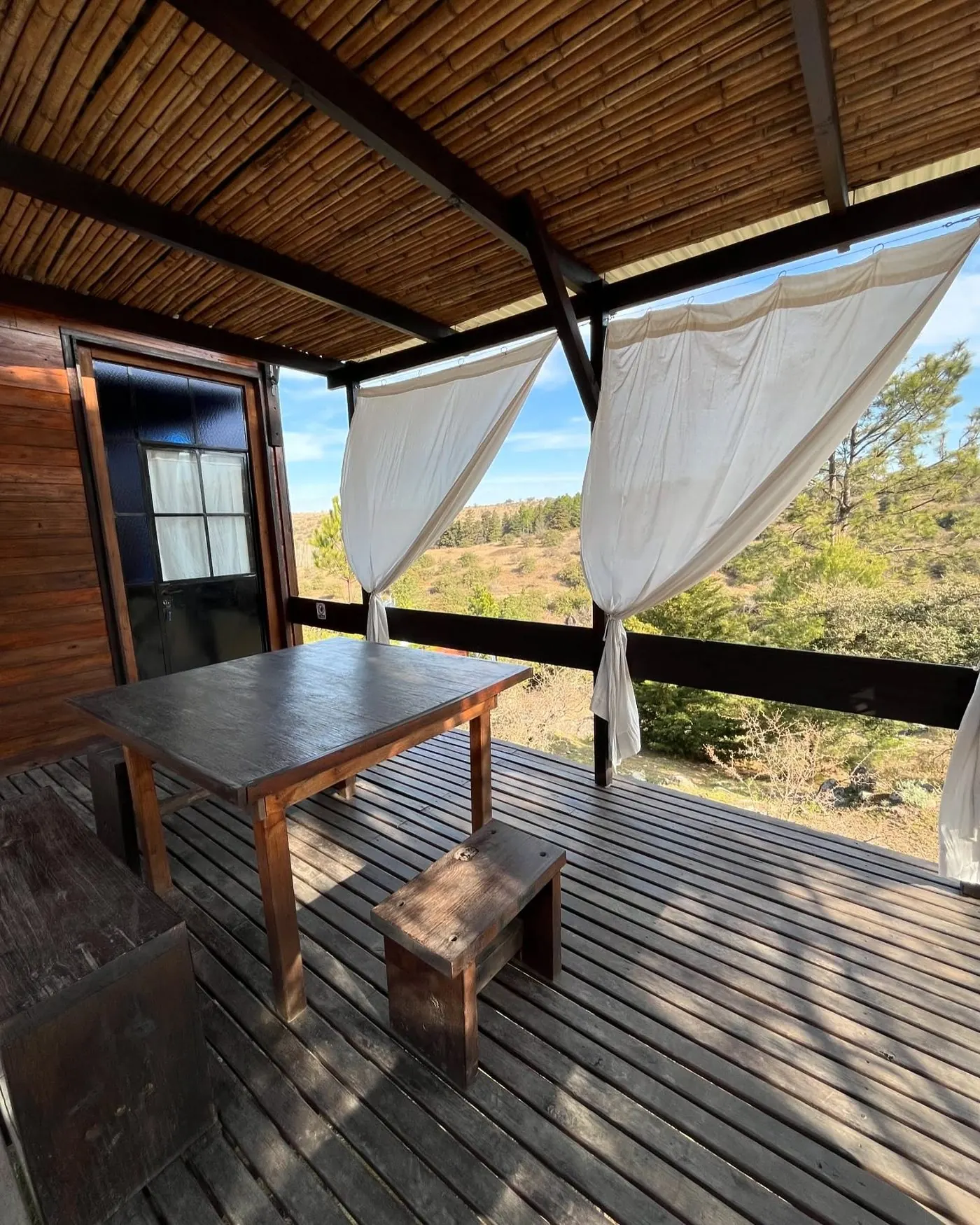 Galería de la cabaña con vista abierta a las sierras de Córdoba
